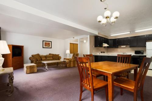 a kitchen and living room with a wooden table and chairs at Super 8 by Wyndham Port Angeles at Olympic National Park in Port Angeles