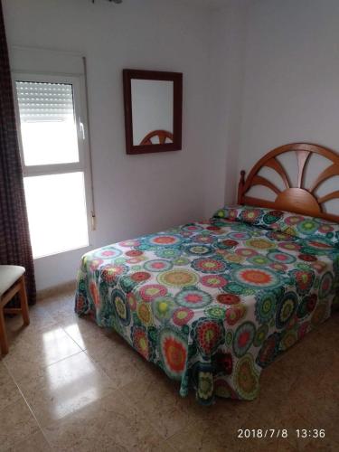 a bedroom with a bed with a colorful comforter at MOJACAR PLAYA in Mojácar