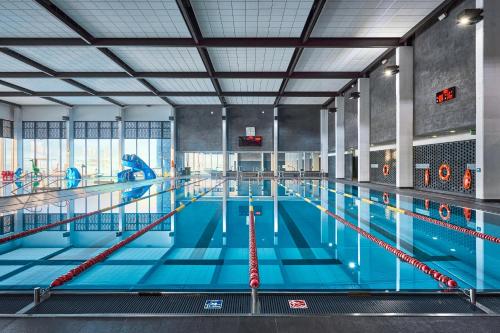 a large indoor swimming pool with blue water at Termy Warmińskie in Lidzbark Warmiński