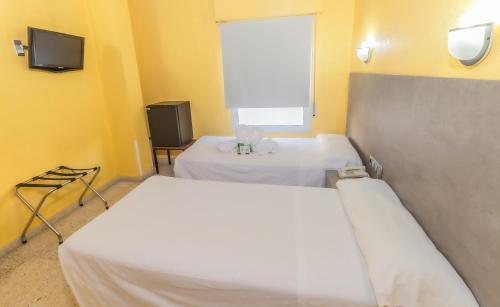 a hospital room with two beds and a tv at Hotel Universal Murcia in Murcia
