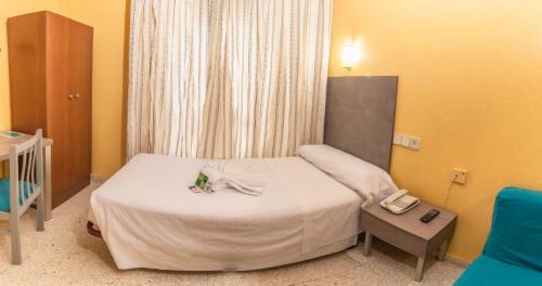 a hotel room with a bed with a phone and a phone at Hotel Universal Murcia in Murcia