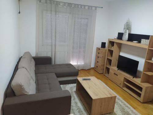 uma sala de estar com um sofá e uma televisão em Relax em Obrenovac
