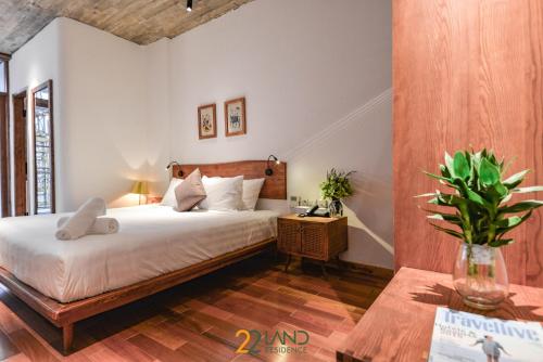 a bedroom with a bed and a table with a plant at 22Land Hotel & Residence in Hanoi