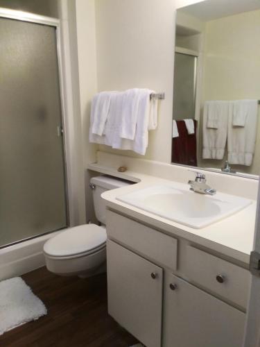 a bathroom with a sink and a toilet and a mirror at Casa Allegro - 55+ Active Vacations Paradise in Sun City West