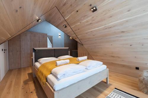 Cama en habitación con techo de madera en udanypobyt Apartament LUXURY Strążyska 31 en Zakopane
