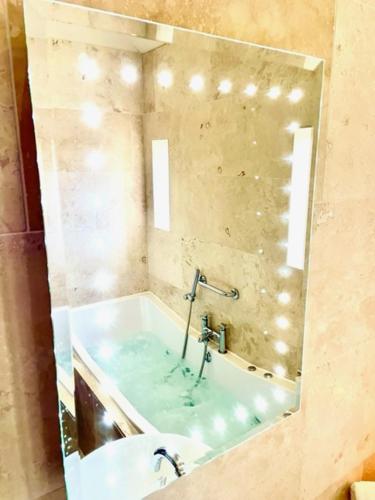 a reflection of a bath tub in a mirror at Oak Tree Inn in Brafferton
