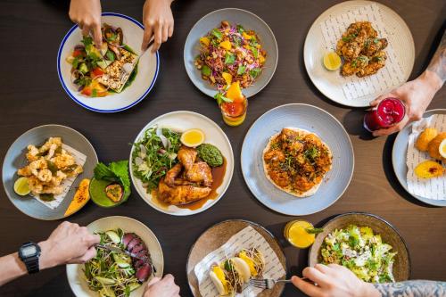 a group of people sitting around a table with plates of food at Staybridge Suites Dubai Financial Centre by IHG in Dubai