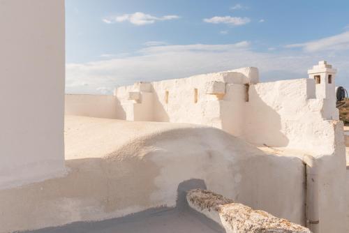 a white building with an arch on the side at MASSERIA SCALEDDA in Manduria