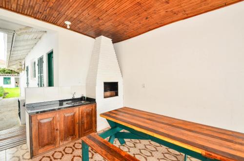cocina con banco de madera y fregadero en Recanto manezinho - Casa frente mar em Ponta das Canas N1793, en Florianópolis