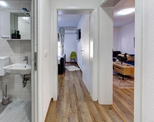 a hallway leading to a bathroom with a sink at Guesthouse Check In in Stolac