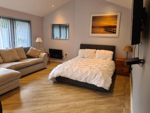 1 dormitorio con 1 cama y 1 sofá en Dean Clough Lodge - Contemporary self contained studio, en Wilpshire