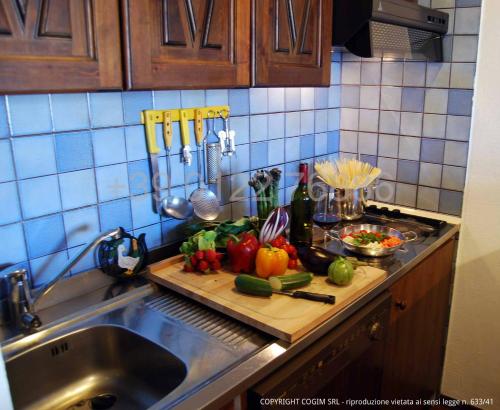 a kitchen counter with a cutting board with vegetables on it at Resort Palace Sestriere 1 e 2 in Sestriere