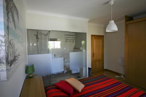a bedroom with a bed and a bathroom at Villa Vista Mar Piscina Suites in Fuzeta