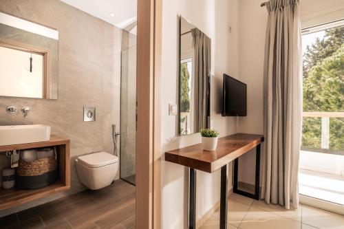 a bathroom with a toilet and a sink at Oresteia Executive Villa, a Flamboyant Retreat, By ThinkVilla in Tragaki