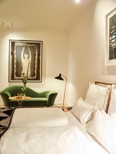 a bedroom with a bed and a green couch at Townhouse by THE QVEST in Cologne