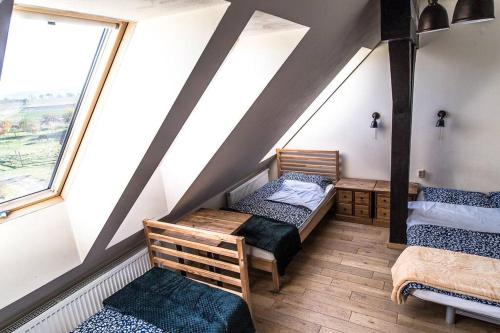 Pokój na poddaszu z 2 łóżkami i oknem w obiekcie WYSPA KONI - urocze gospodarstwo agroturystyczne w mieście Ostroszowice