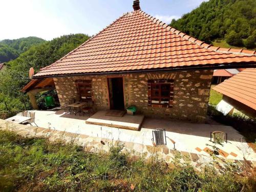 a small stone house with a red roof at Apartment Old House in Podgorica