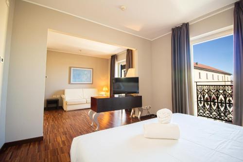 ノヴァーラにあるホテル カブールのベッドとリビングルームが備わるホテルルームです。