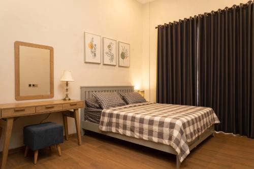 普禾加多的住宿－Hening Pool Villa，一间卧室配有一张床、一张书桌和一面镜子