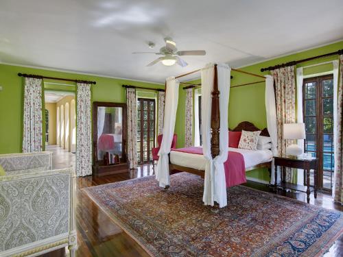 a bedroom with a canopy bed and green walls at Colleton Great House in Saint Peter