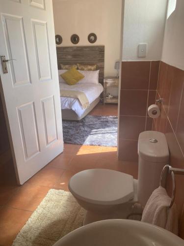łazienka z toaletą i łóżko w pokoju w obiekcie Lime Court One w mieście Pretoria