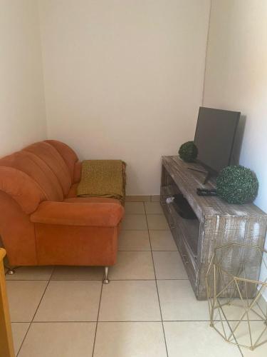 a living room with a couch and a tv at Lime Court One in Pretoria