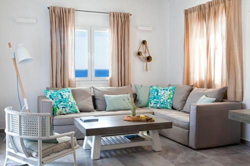 Amperian Mykonos Suites & Villas في مدينة ميكونوس: غرفة معيشة مع أريكة وطاولة