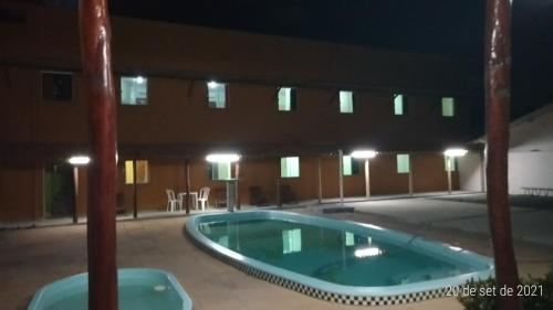 an empty swimming pool in a building at night at Pousada Recanto Lagoa Azul in Baixio