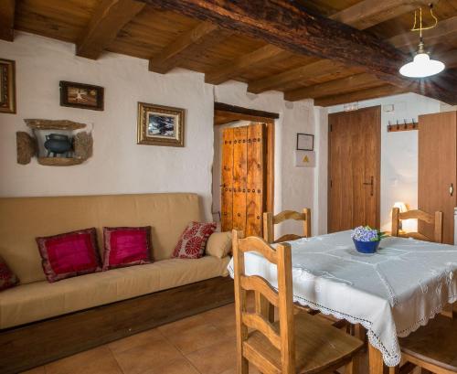 salon ze stołem i kanapą w obiekcie Apartamentos Rurales Los Vergeles w mieście Valverde de la Vera