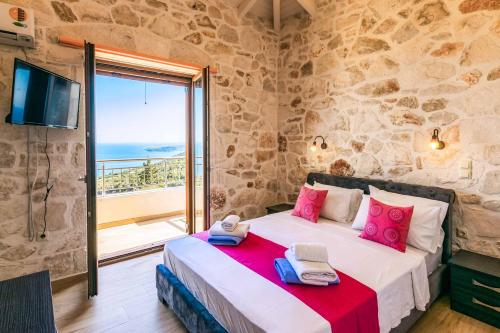 una camera con letto e vista sull'oceano di Villa Stephania a Orthoniaí
