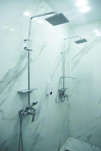 a bathroom with a shower with white marble walls at SPA Resort HeRICH in Bukovel
