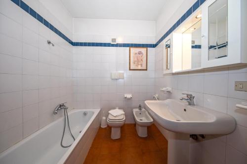 a bathroom with a sink and a tub and a toilet at Residence Edera 18 by Wonderful Italy in Polpenazze del Garda