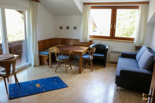 - un salon avec une table et un canapé bleu dans l'établissement Haus Alpina, à Sonnenalpe Nassfeld