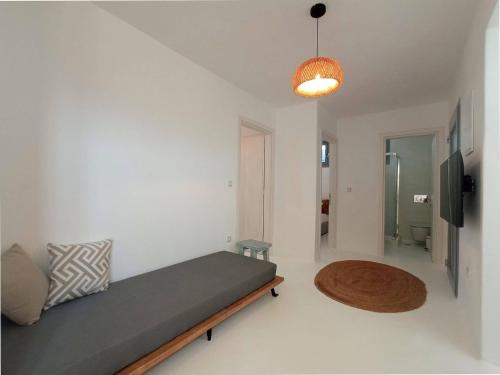 a room with a bed and a television and a table at The Nine Graces - Kastraki Villas with Private Swimming Pool in Kastraki Naxou