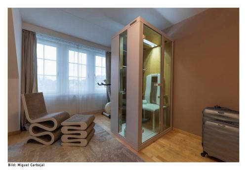 a bathroom with a mirror and a chair and a sink at City, Lake and Luxury in Zurich