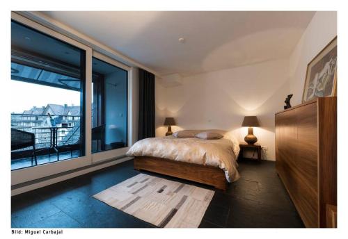 a bedroom with a bed and a large window at City, Lake and Luxury in Zürich