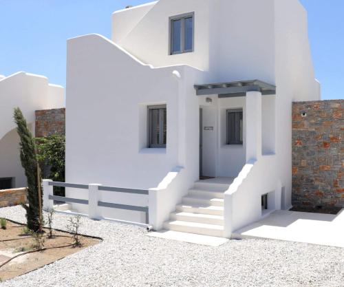 a white house with white stairs and a fence at The Nine Graces - Kastraki Villas with Private Swimming Pool in Kastraki Naxou