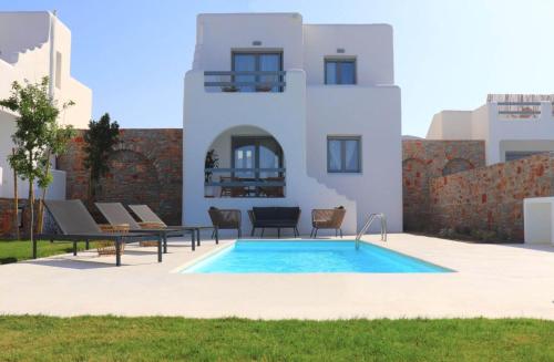 a villa with a swimming pool in front of a house at The Nine Graces - Kastraki Villas with Private Swimming Pool in Kastraki Naxou