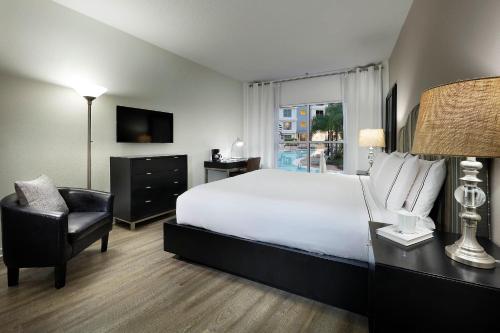 a bedroom with a large white bed and a chair at Meliá Orlando Celebration in Orlando