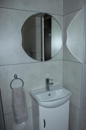 La salle de bains est pourvue d'un lavabo et d'un miroir. dans l'établissement Shandi Accommodation, à Witbank