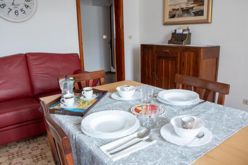 una mesa de comedor con platos y tazones. en Tal Borc en San Vito al Torre