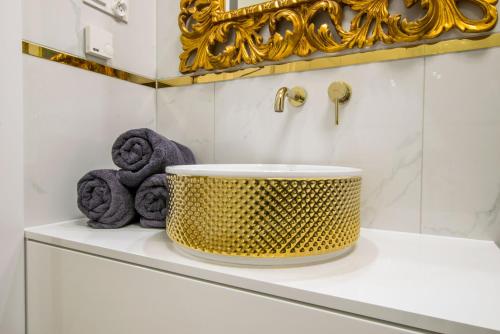 a bathroom with a sink and towels on a shelf at Central Apartments Goleniow Luxury in Gollnow