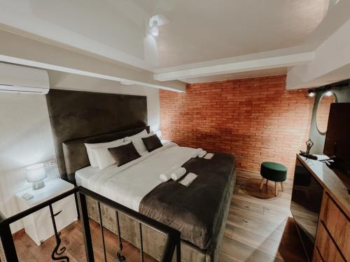 a bedroom with a bed and a brick wall at Luxury Duplex Suites - City Center in Tbilisi City