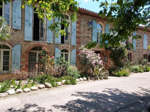 a brick building with flowers in front of it at Domaine De La Tannerie chambres d'hôtes et appartements in Prades