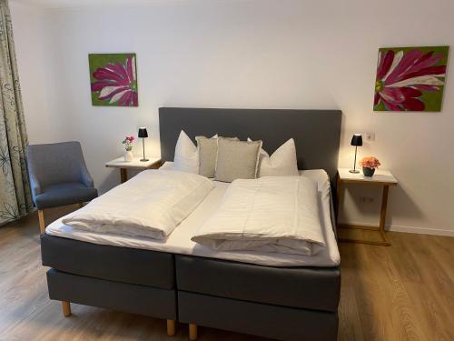 a bed in a bedroom with two tables and a chair at Hotel Ostermann in Treis-Karden