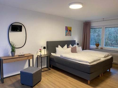 una camera con un grande letto e uno specchio di Hotel Ostermann a Treis-Karden