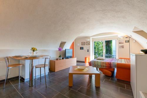 a living room with a couch and a table in a room at Casa di campagna Tony con piscina e vista lago in Gravedona