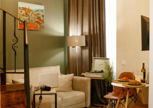 a living room with a couch and a table with a laptop at Luxury Duplex Suites - City Center in Tbilisi City
