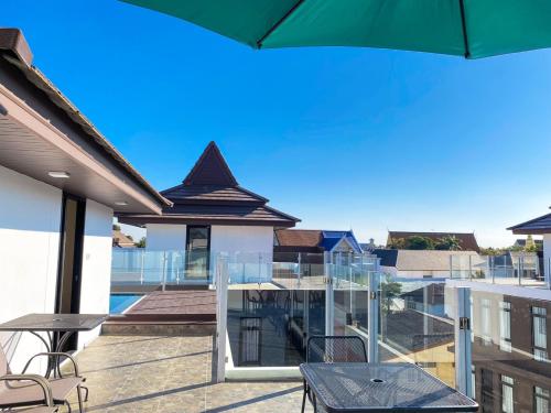 a balcony with a table and chairs and an umbrella at DE LUXE BOUTIQUE & rooftop in Chiang Mai