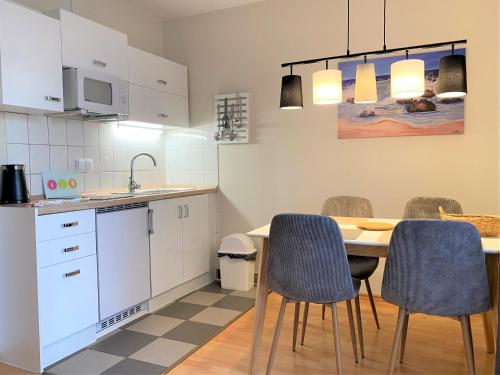 eine Küche mit einem Tisch und Stühlen im Zimmer in der Unterkunft Appartementhaus Sonnenschein in Binz